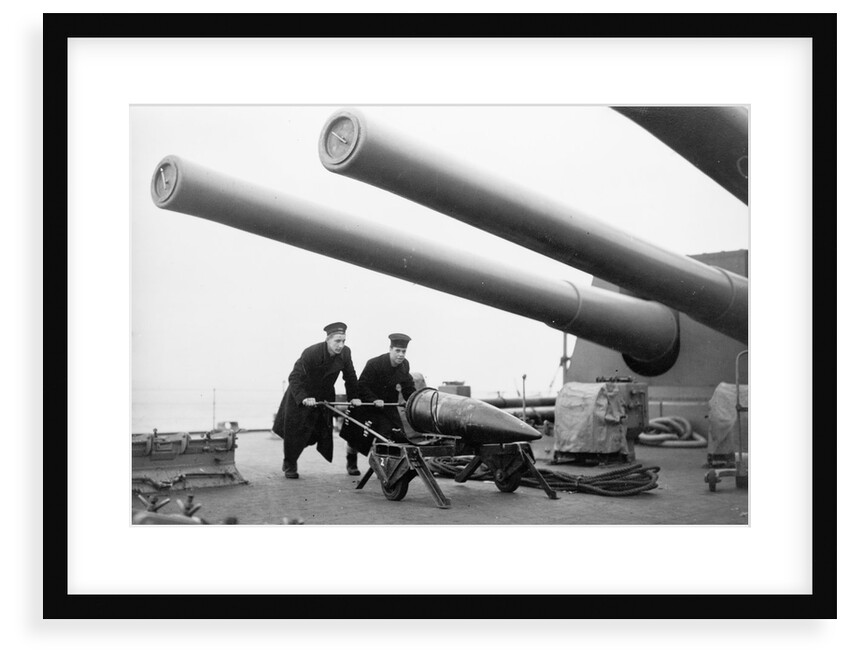 Two ratings pushing a 14-inch shell on a trolley on the battleship 'King George V' (1939). King George V carried about 800 shells for her 10 guns when loaded. by unknown