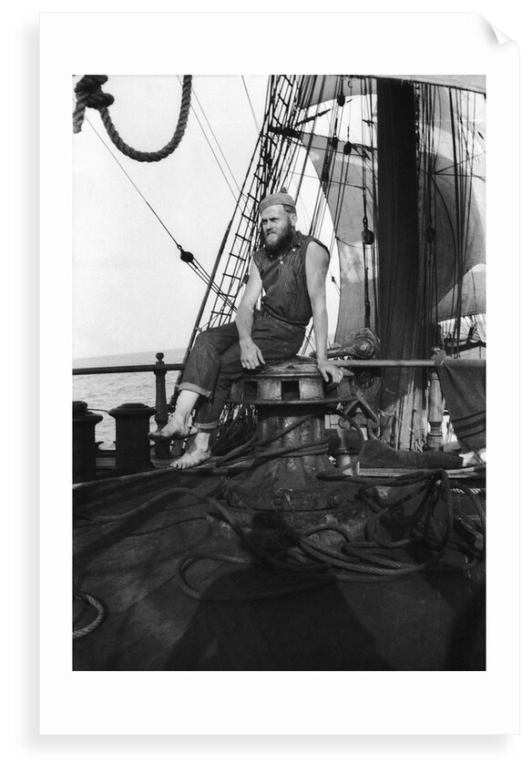 One of the crew on the forecastle head capstan by Alan Villiers