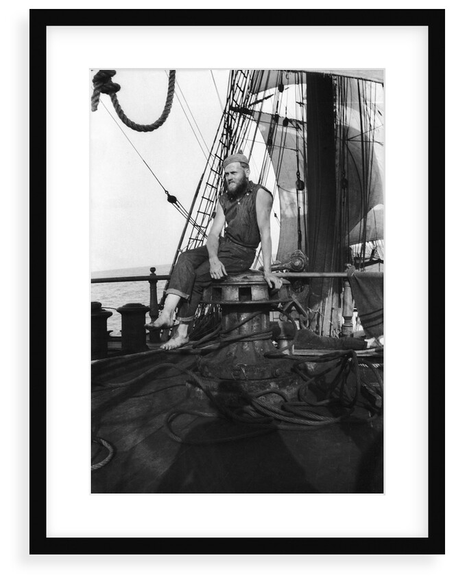 One of the crew on the forecastle head capstan by Alan Villiers