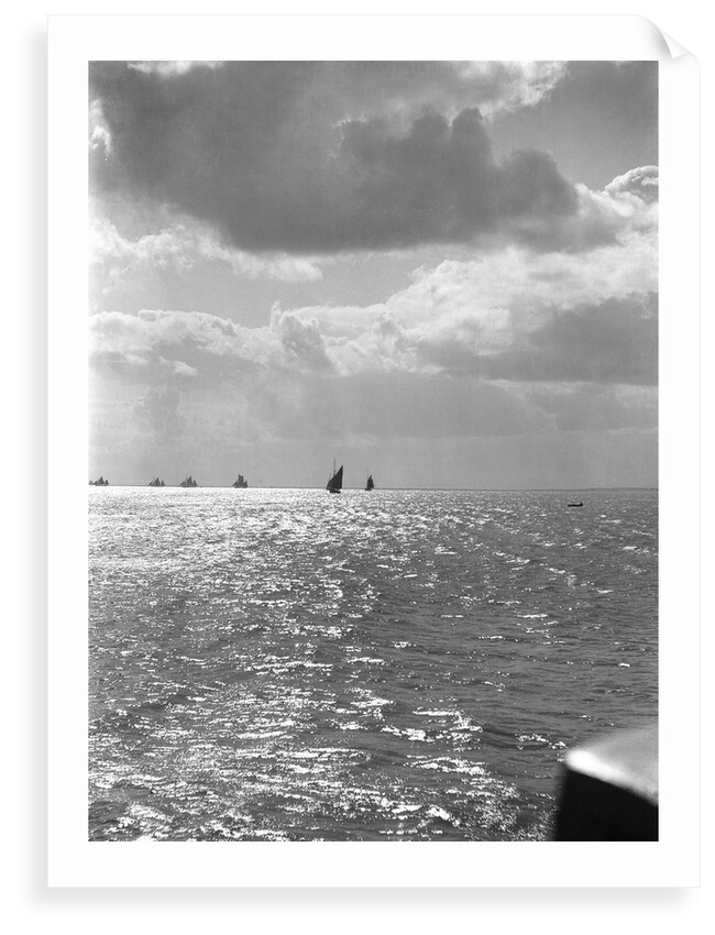 The sunlit North Sea from the harbour entrance with a number of trawlers under sail on the horizon at Lowestoft, Suffolk by Smiths Suitall Ltd.