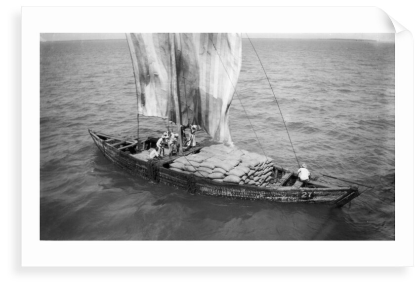 Indigenous boat at sea, laden with sacks by unknown
