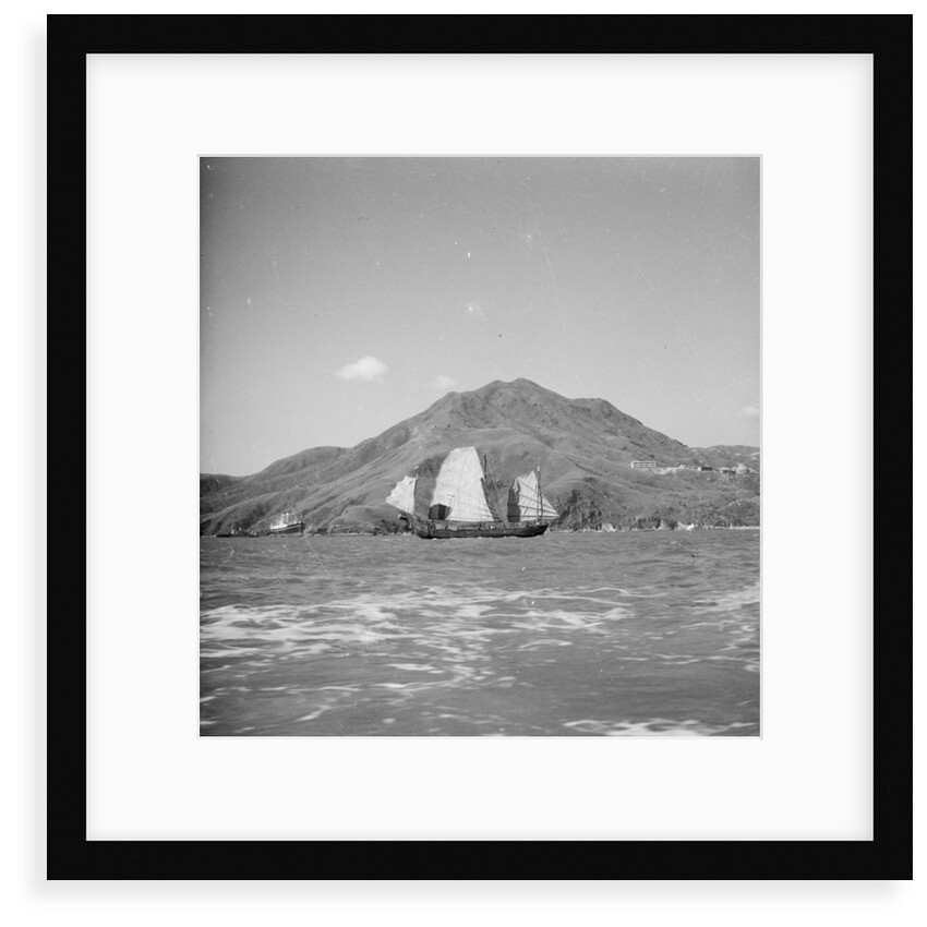 A distant starboard beam view of a Yeungkong fisher type junk under sail in Sai Wan Bay off Lyemun, Hong Kong by David Watkin Waters