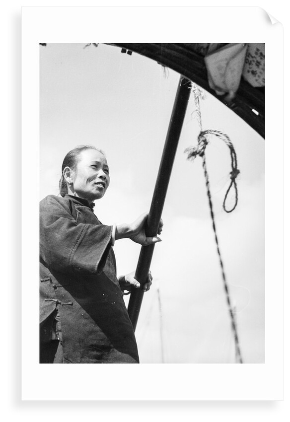 A middle aged Chinese woman in a sampan in Hong Kong harbour by David Watkin Waters
