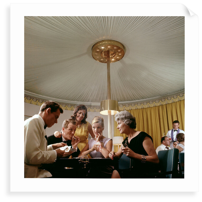 Passengers in smart evening dress, aboard an unspecified cruise liner, enjoy the thrilling distraction of a card game by Marine Photo Service