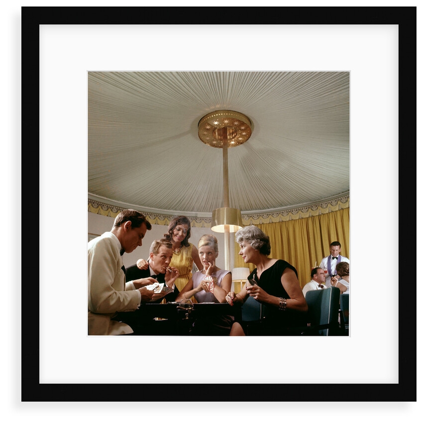 Passengers in smart evening dress, aboard an unspecified cruise liner, enjoy the thrilling distraction of a card game by Marine Photo Service