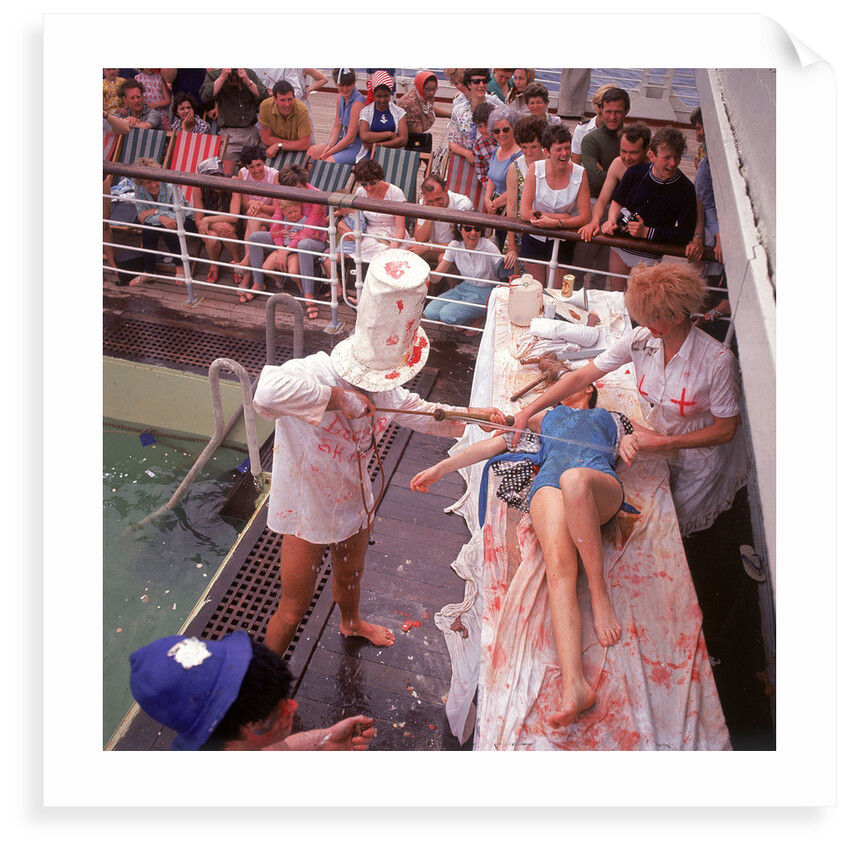 Macabre comic entertainment aboard an unspecified cruise ship, with a female passenger prostrate on a bloody slab - perhaps a variant of the Crossing the Line (the Equator) ceremony? by Marine Photo Service