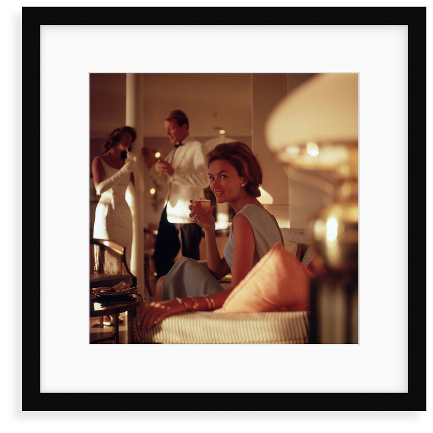 A smartly attired female passenger enjoys an evening tipple aboard an unspecified cruise ship by Marine Photo Service