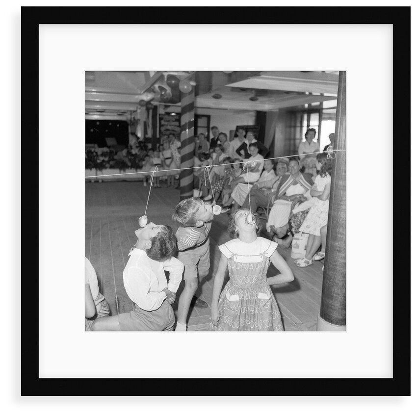 Three children in the "Apple Eating" contest, possibly in the ballroom of the 'Chusan' (1950) by Marine Photo Service
