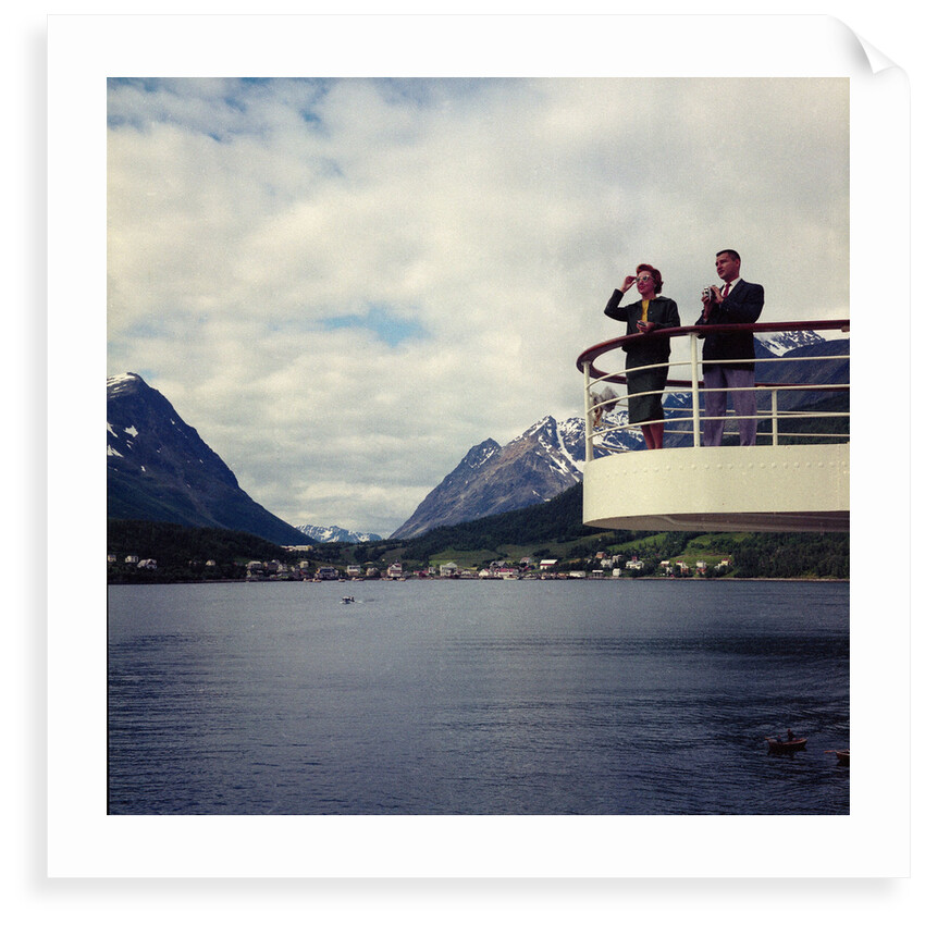 A view looking towards Lyngseidt in the background: an unidentified couple stand on the after wing of 'Gripsholm' (1957) by Marine Photo Service