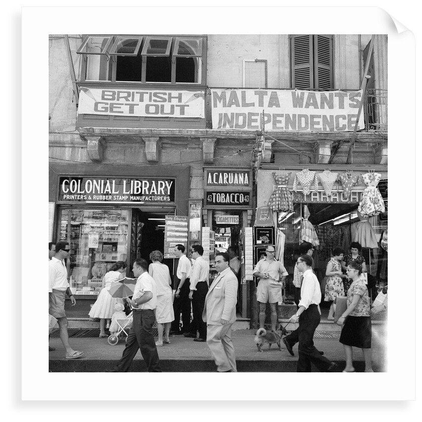 A view of shops with anti-British and pro-Independence signs, possibly on Kings Street, Valetta, Malta. by Marine Photo Service