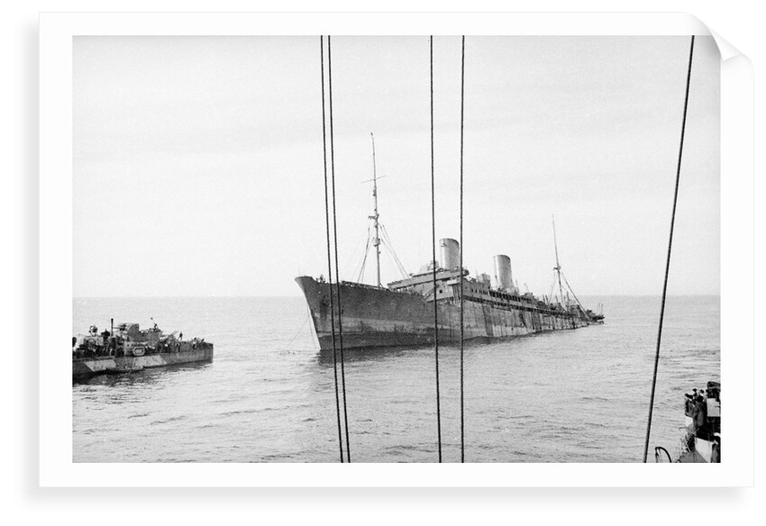 Photograph of 'Windsor Castle' sinking in 1943. Port bow view well down by the stern with the escort destroyer 'Farndale' (1940) near the bow. by Lt EJ Manners