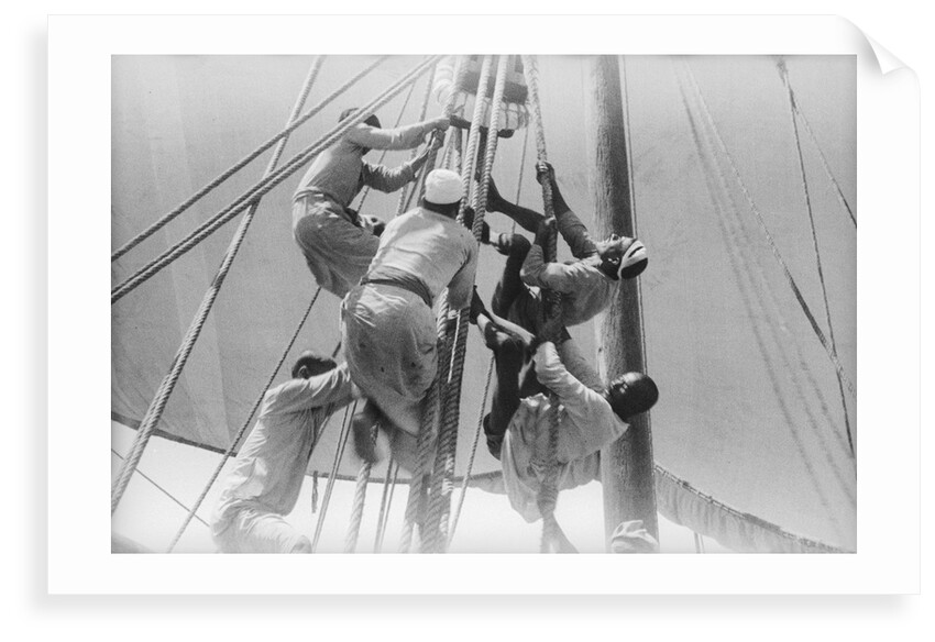 Sailors climbing the halyard blocks by Alan Villiers