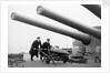 Two ratings pushing a 14-inch shell on a trolley on the battleship 'King George V' (1939). King George V carried about 800 shells for her 10 guns when loaded. by unknown