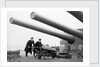 Two ratings pushing a 14-inch shell on a trolley on the battleship 'King George V' (1939). King George V carried about 800 shells for her 10 guns when loaded. by unknown
