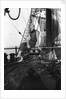 One of the crew on the forecastle head capstan by Alan Villiers