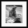 American soldier peeling onions while wearing a gas mask by Alan Villiers