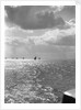 The sunlit North Sea from the harbour entrance with a number of trawlers under sail on the horizon at Lowestoft, Suffolk by Smiths Suitall Ltd.