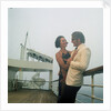 A misty evening offers amorous opportunities on deck for a romantic, smartly dressed, couple on a cruise ship by Marine Photo Service