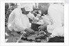 Pearl buyers examining pearls by Alan Villiers