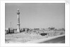 Minaret, stacked building stone and new buildings, Manama by Alan Villiers