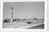 Minaret, stacked building stone and new buildings, Manama by Alan Villiers