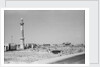 Minaret, stacked building stone and new buildings, Manama by Alan Villiers
