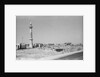 Minaret, stacked building stone and new buildings, Manama by Alan Villiers