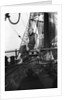 One of the crew on the forecastle head capstan by Alan Villiers