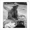 American soldier peeling onions while wearing a gas mask by Alan Villiers