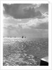 The sunlit North Sea from the harbour entrance with a number of trawlers under sail on the horizon at Lowestoft, Suffolk by Smiths Suitall Ltd.