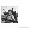 A portrait of a young girl in a sampan in Aberdeen harbour, Hong Kong. by David Watkin Waters