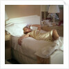 Modern convenience aboard a cruise liner: a female passenger reclines in bed whilst making a phone call; the ship and the conversation's content are unspecified by Marine Photo Service