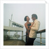 A misty evening offers amorous opportunities on deck for a romantic, smartly dressed, couple on a cruise ship by Marine Photo Service