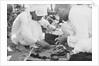 Pearl buyers examining pearls by Alan Villiers