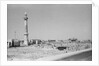 Minaret, stacked building stone and new buildings, Manama by Alan Villiers