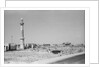 Minaret, stacked building stone and new buildings, Manama by Alan Villiers