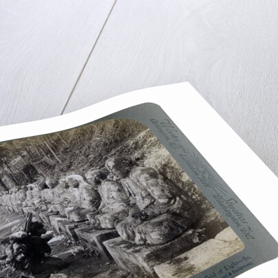 Peasant praying before a row of statues of the God of Light, Daiya river, Nikko, Japan by Underwood & Underwood