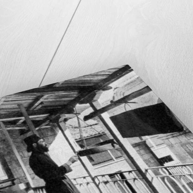 Monk sounding the call to prayer on a gong, Greece by Nomias