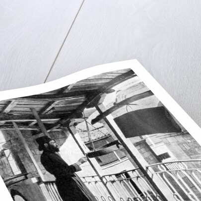 Monk sounding the call to prayer on a gong, Greece by Nomias