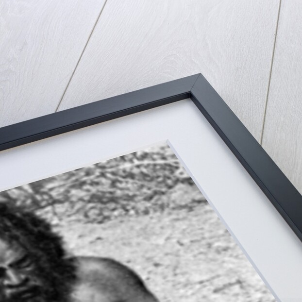 A man from the Warramunga tribe making a stone axe head, Australia by Spencer and Gillen