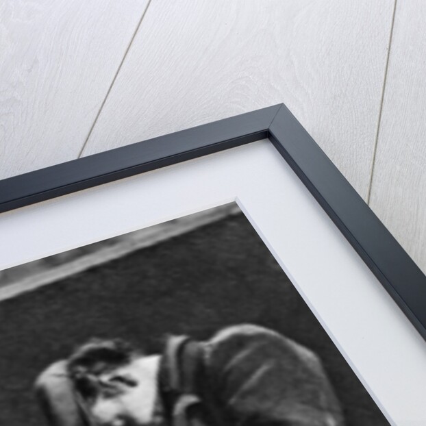 A man sleeping on Blackfriars Bridge, London by Walter Benington