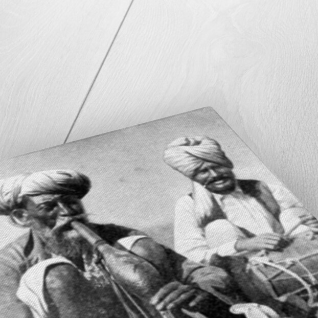 Charming the venom from a cobra; a snake charmer with a mongoose, India by JH Powell