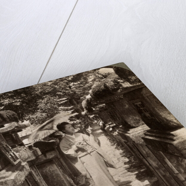 A woman Shinto devotee counting the stone lanterns, Kasuga Shrine, Nara, Japan by Underwood & Underwood