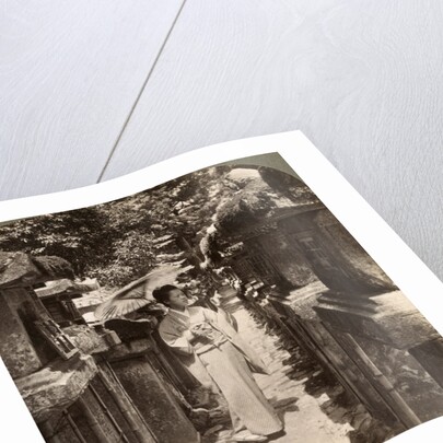 A woman Shinto devotee counting the stone lanterns, Kasuga Shrine, Nara, Japan by Underwood & Underwood