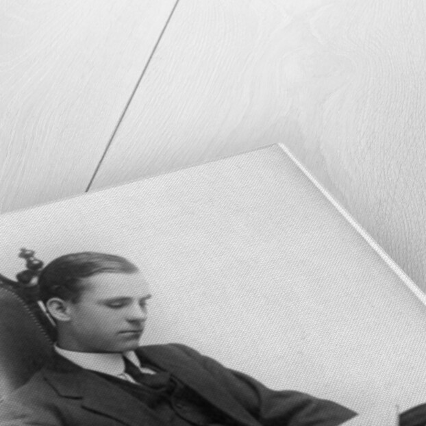Man sitting in a chair reading a book by Anonymous