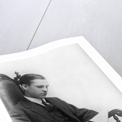Man sitting in a chair reading a book by Anonymous