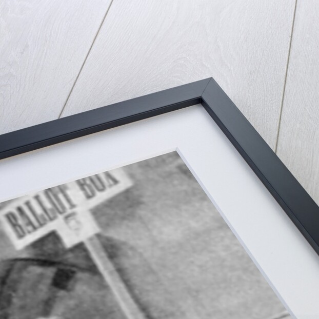 A woman recording her vote at the ballot box by Anonymous
