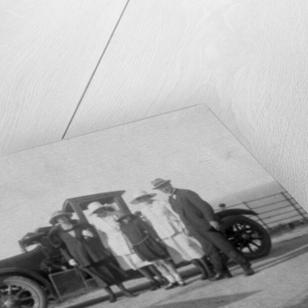 A group of people in front of their car at the seaside by Anonymous