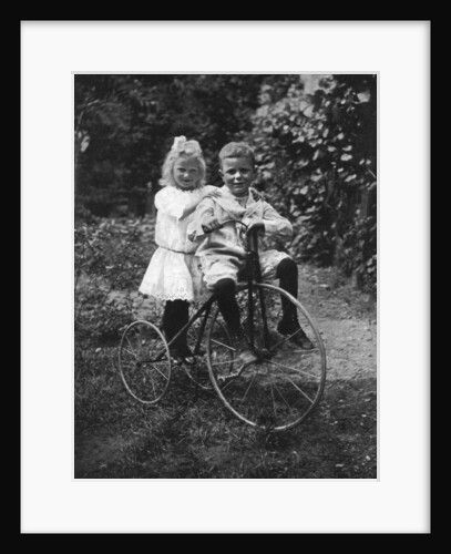 Two children on a tricycle by CW Perry