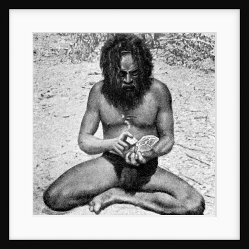 A man from the Warramunga tribe making a stone axe head, Australia by Spencer and Gillen